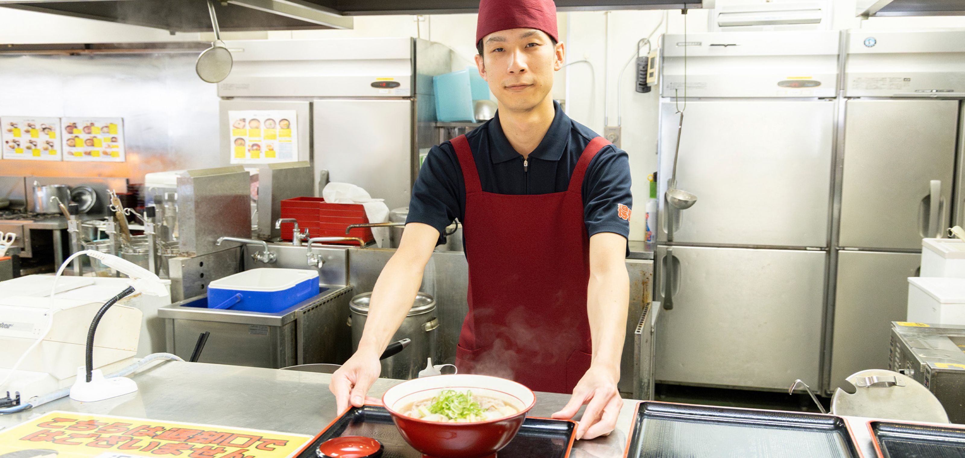 出来上がったラーメンを提供するスタッフ
